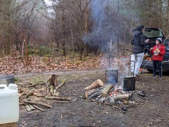 Pans boiling over an open fire in the forest