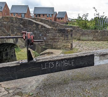 A chalk scribble on a lock gate, "Let's Bimble"