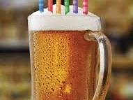 transparent mug of beer with birthday candles in the foam