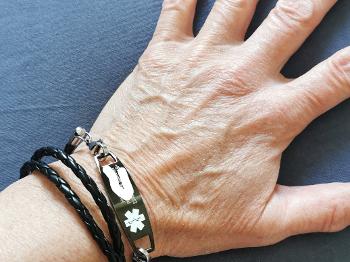 Medical bracelet mentioning Prednisone and GCA with contact information and blood group 