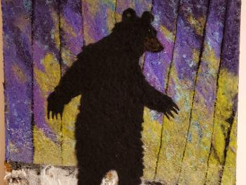 Textile artwork of bear on multicolor background