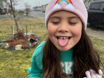 Child feeling snow on her tongue.