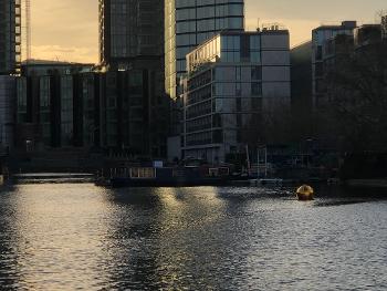 Canal basin fringed by office towers - with floating golden orb catching early morning sun