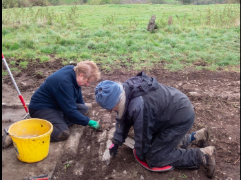 2 people excavating with trowels