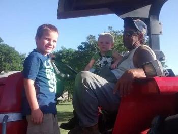 Photo of Jimmy and two grandsons on tractor