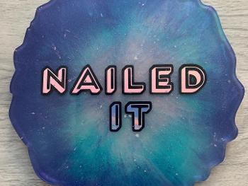 Picture of a resin coaster with nailed it written in the centre