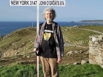 Photo of me standing next to the iconic signpost at Land's End. 