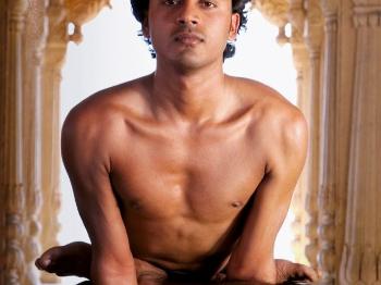 A yoga practitioner performing a variation of a lotus pose. 
