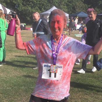 Runner covered in coloured powder raising a glass