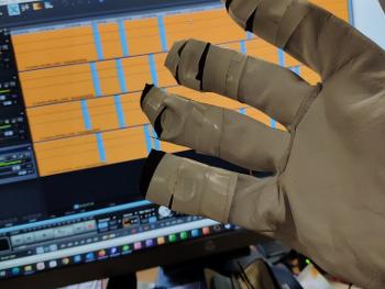 glove with wires in front of monitor showing audio file