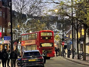 Bus on street with Christmas lights.