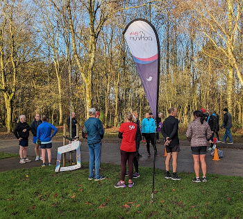 A group of runners chatting after parkrun.
