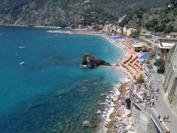 The blue sea and beach with parasols in the Cinque Terra region of Italy 