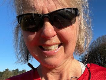 Female runner wearing red top and sunglasses 