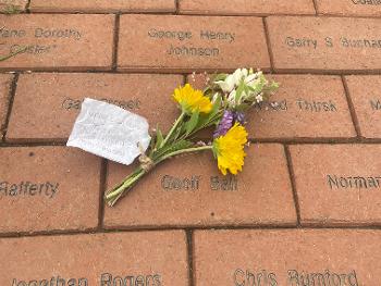 Flowers by an engraved brick on the MSA ‘Path to a cure’