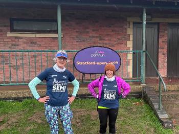 2 runners by the Stratford upon Avon parkrun sign