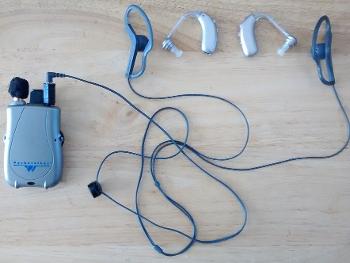Current hearing aid set up I use, versus the behind-the-ear units I no longer use.