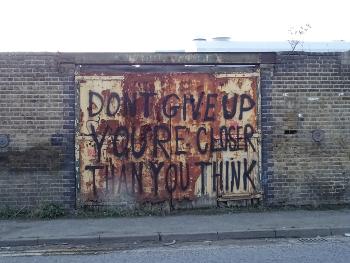 Graffiti on a rusty pair of gates: 
DON'T GIVE UP.  YOU'RE CLOSER THAN YOU THINK.