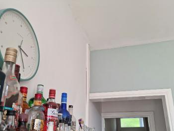 Light blue kitchen wall, clock of the same shade on a different wall.